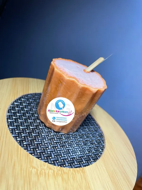 Orange Abele ice pop on a bamboo board with the Mimi's Global sticker