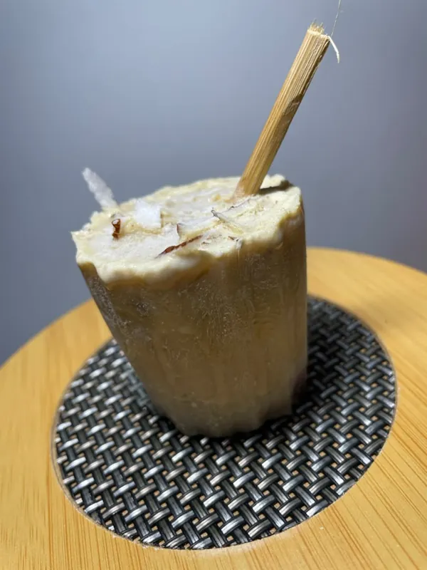 Vanilla Abele ice pop topped with coconut shavings on a bamboo board